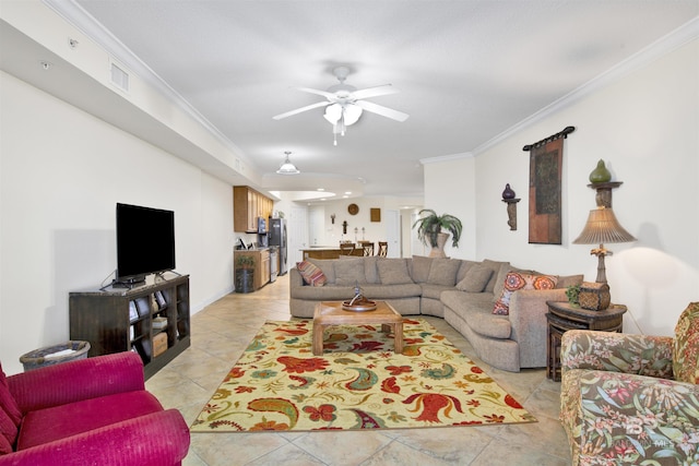 living room featuring light tile patterned flooring, ceiling fan, visible vents, and crown molding