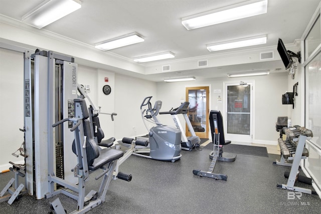 exercise room with baseboards, ornamental molding, and visible vents