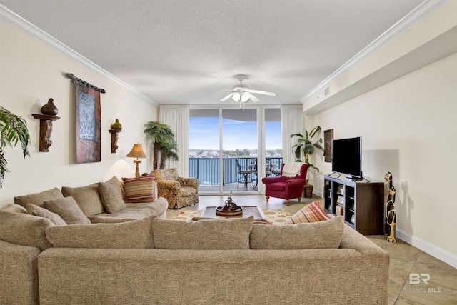 living area with crown molding, a ceiling fan, a wall of windows, a textured ceiling, and baseboards