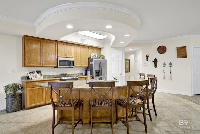 kitchen with ornamental molding, a breakfast bar area, and appliances with stainless steel finishes