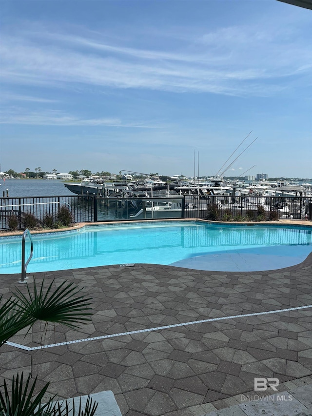 view of pool featuring a water view and a patio area