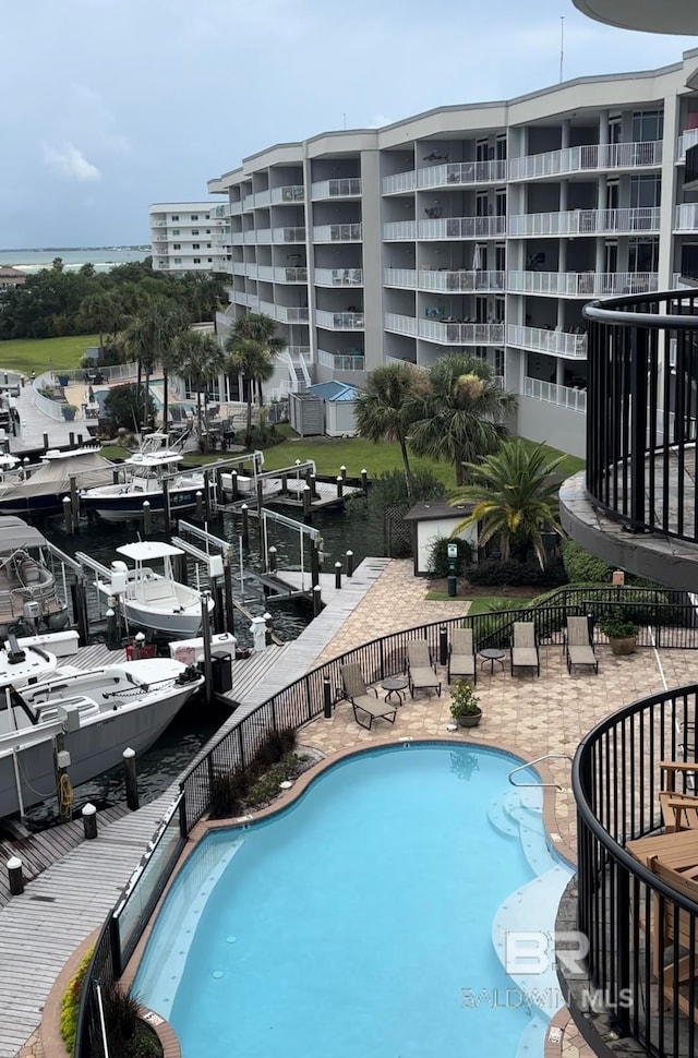 view of pool featuring a water view and a patio area