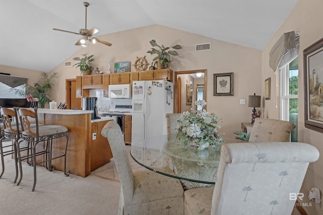 dining room with lofted ceiling, ceiling fan, and light carpet