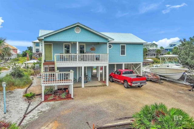 back of house with covered porch and a carport