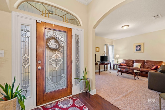 foyer featuring a textured ceiling and dark wood-type flooring