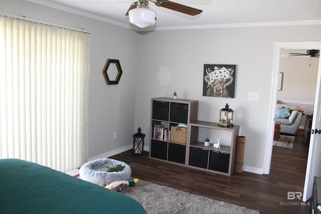 bedroom featuring a textured ceiling, wood finished floors, baseboards, and ornamental molding