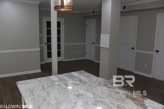 interior space with dark wood-style floors, visible vents, crown molding, and baseboards