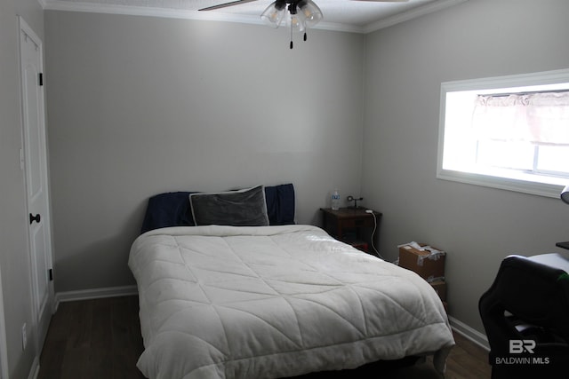 bedroom featuring baseboards, wood finished floors, and crown molding