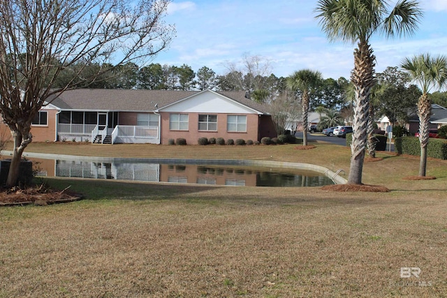 back of house with a lawn and a sunroom