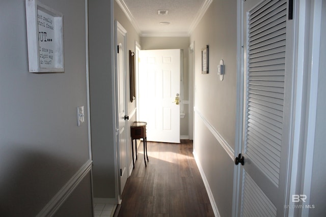 corridor featuring baseboards, dark wood-type flooring, and crown molding