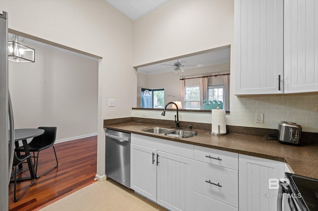 kitchen with white cabinets, ceiling fan with notable chandelier, sink, hanging light fixtures, and stainless steel appliances