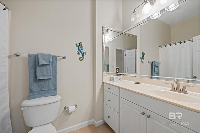 bathroom with toilet, vanity, and tile patterned floors