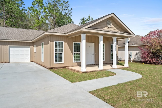 view of front of house with a garage, a front yard, and a porch