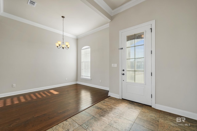 foyer entrance with wood-type flooring, ornamental molding, and an inviting chandelier