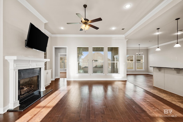 unfurnished living room featuring ceiling fan with notable chandelier, dark hardwood / wood-style flooring, and crown molding