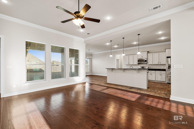 unfurnished living room with ceiling fan, dark hardwood / wood-style floors, and ornamental molding