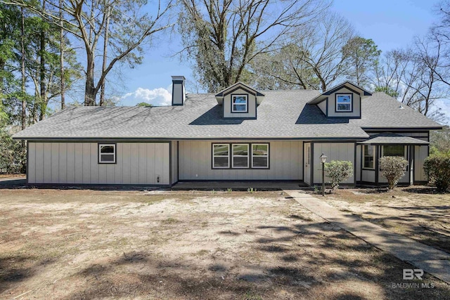 view of front of property featuring a shingled roof and a chimney