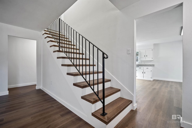 staircase with wood finished floors and baseboards