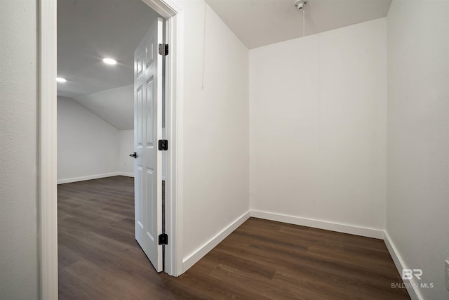 hall with vaulted ceiling, dark wood finished floors, and baseboards