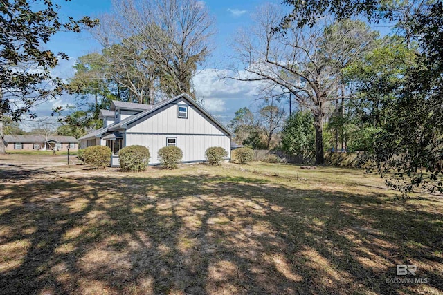 view of home's exterior with fence and a yard