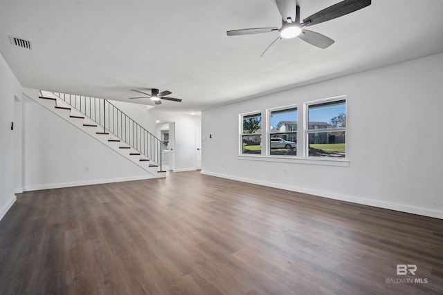 unfurnished living room featuring baseboards, stairs, visible vents, and wood finished floors