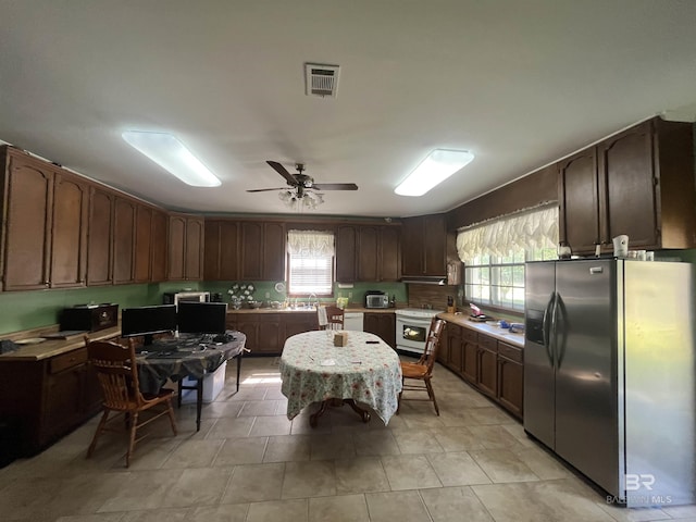 kitchen with stainless steel fridge, light countertops, white dishwasher, visible vents, and a ceiling fan