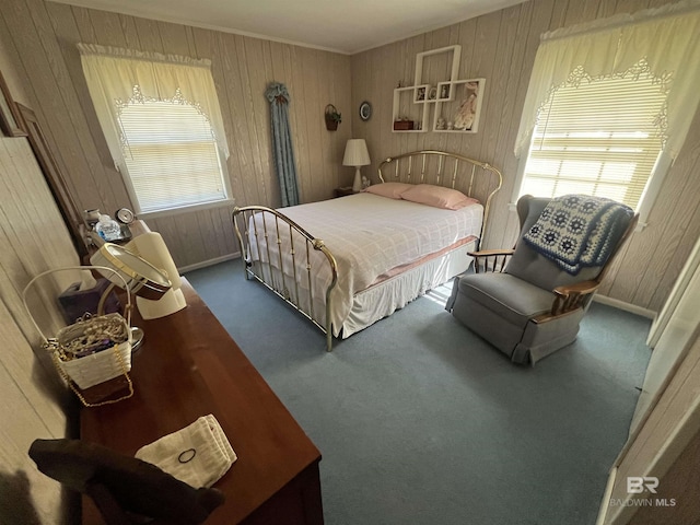 carpeted bedroom featuring wood walls and baseboards