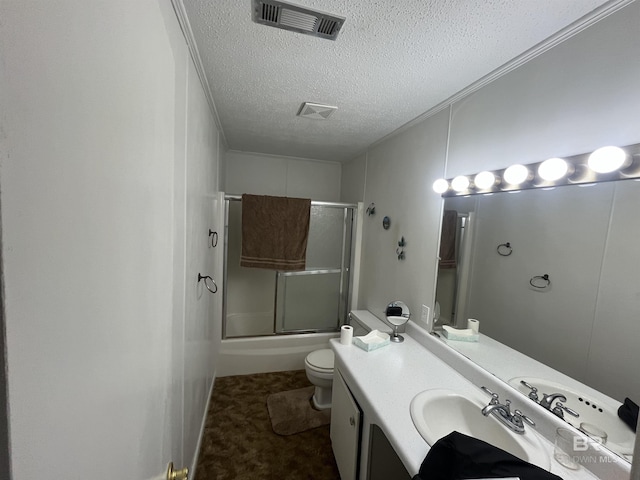 bathroom featuring bath / shower combo with glass door, a textured ceiling, visible vents, toilet, and vanity