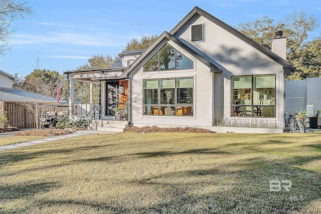 view of front of property featuring a chimney, a front yard, and fence