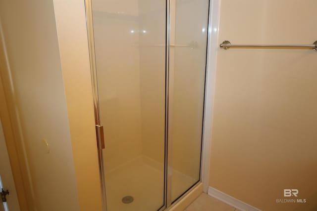 bathroom with baseboards and a stall shower