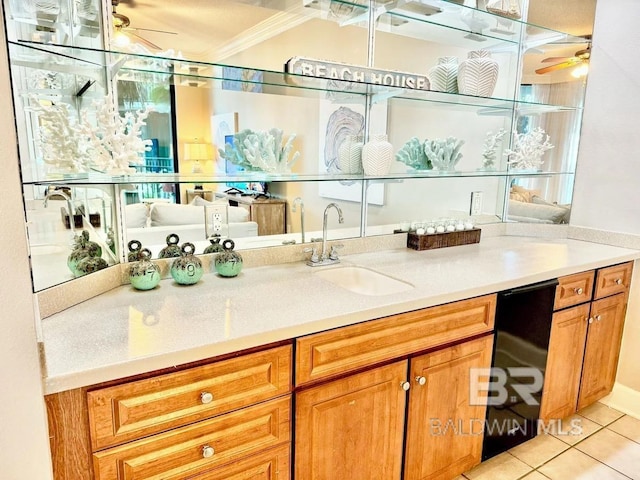 bar with ceiling fan, crown molding, a sink, and light tile patterned floors