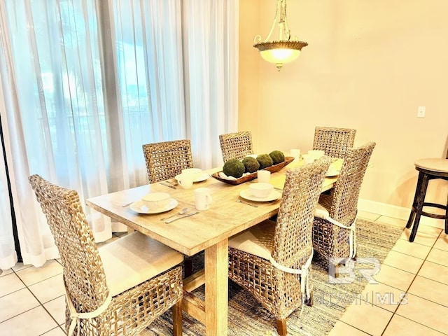 dining space featuring baseboards and light tile patterned floors