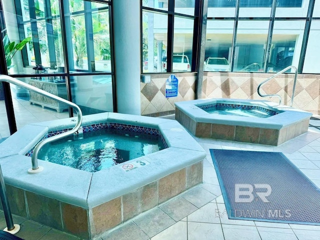 view of swimming pool featuring an indoor hot tub