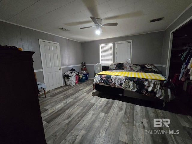 bedroom featuring hardwood / wood-style floors, ceiling fan, and crown molding