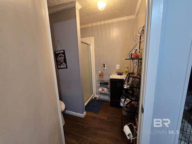 bathroom featuring an enclosed shower, crown molding, sink, wood-type flooring, and toilet