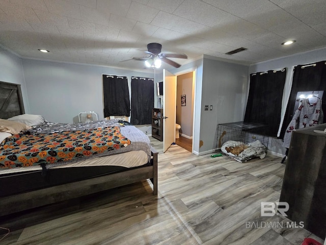 bedroom with ceiling fan, ensuite bathroom, and light hardwood / wood-style flooring