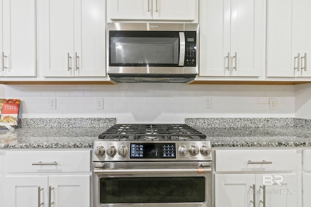 kitchen with tasteful backsplash, light stone counters, white cabinets, and stainless steel appliances