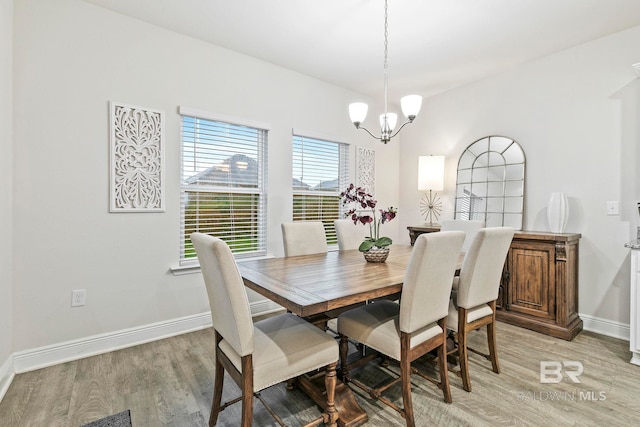 dining area featuring an inviting chandelier and light hardwood / wood-style flooring