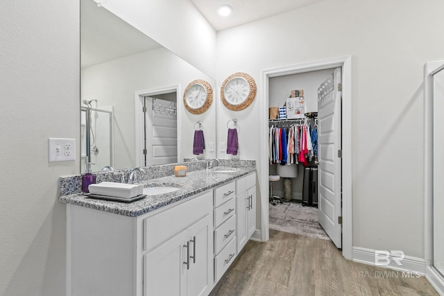 bathroom featuring vanity, an enclosed shower, and hardwood / wood-style flooring