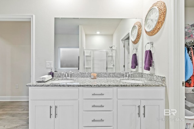 bathroom featuring a shower with door, vanity, and wood-type flooring