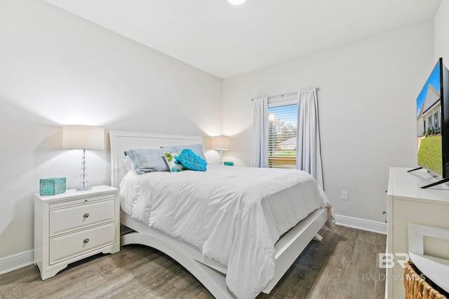 bedroom with dark hardwood / wood-style flooring