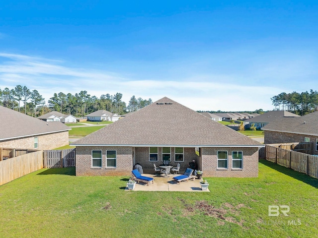 rear view of house featuring a yard and a patio