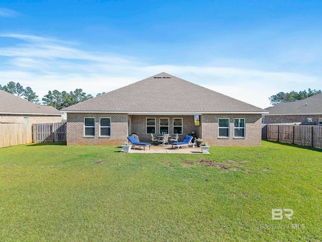 rear view of property featuring a lawn and a patio