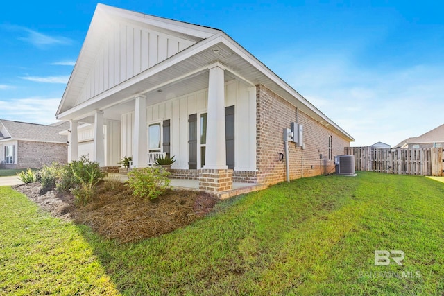 view of property exterior with central air condition unit, a yard, and a porch