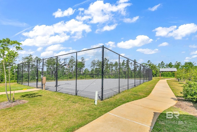 view of sport court with a lawn