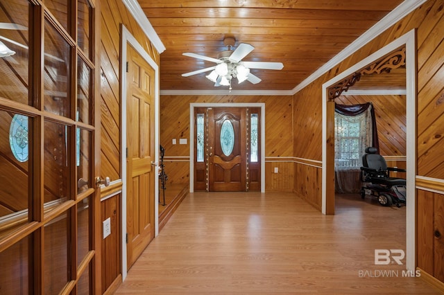 entryway featuring light hardwood / wood-style floors, crown molding, wooden walls, and ceiling fan