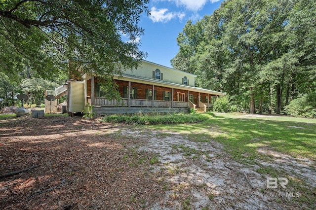 rear view of property featuring covered porch and a lawn