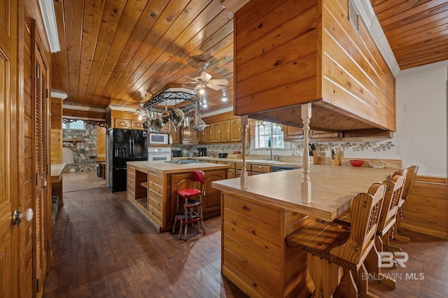 kitchen with ceiling fan, white appliances, dark wood-type flooring, kitchen peninsula, and wood ceiling