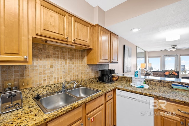 kitchen with sink, dishwasher, light stone counters, ceiling fan, and decorative backsplash