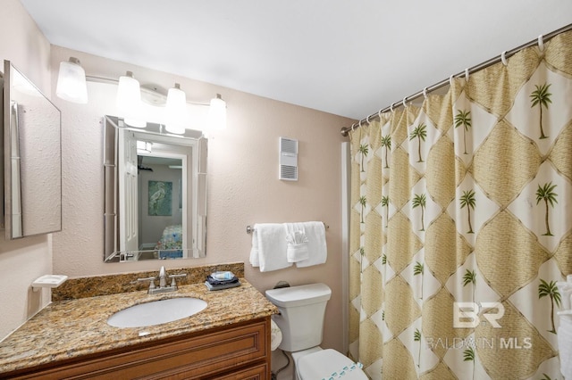 bathroom featuring curtained shower, vanity, and toilet